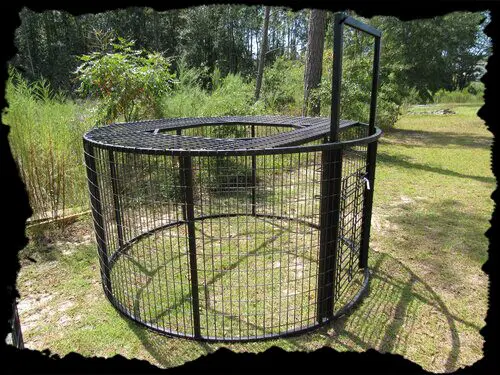 A large metal cage with trees in the background