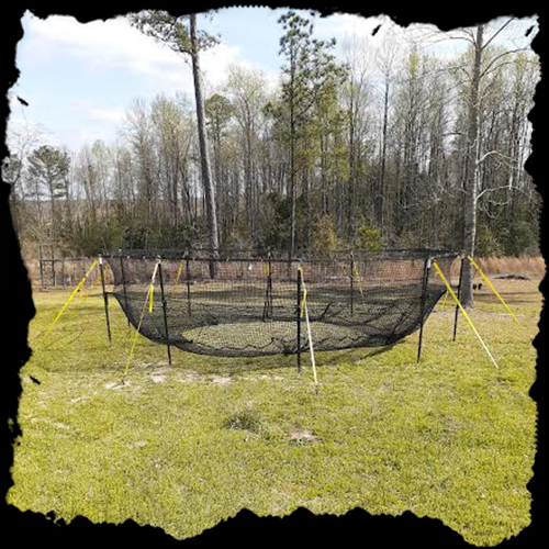 A large round net in the middle of a field.